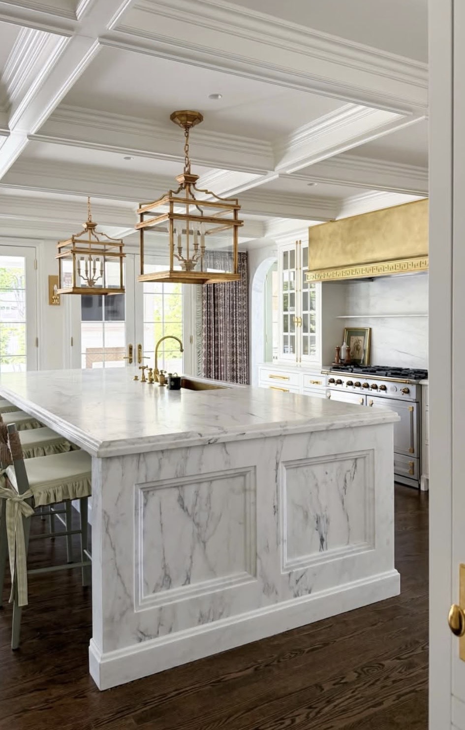 Luxury marble kitchen island with coffered ceiling and gold fixtures